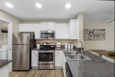 A kitchen with white cabinets and stainless steel appliances.