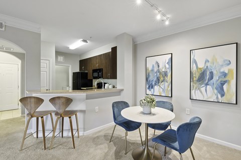A dining area with a white table and blue chairs.