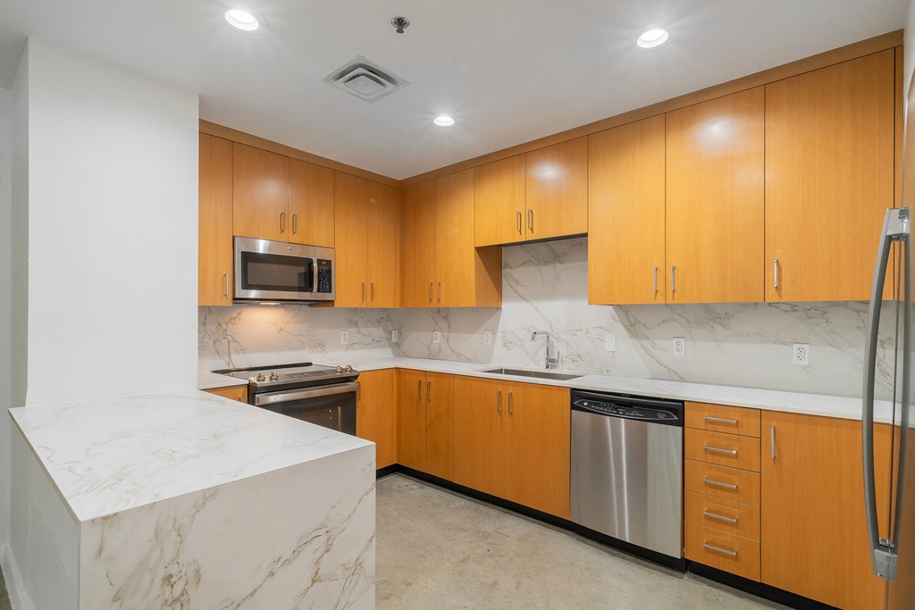 a kitchen with marble counter tops and wooden cabinets