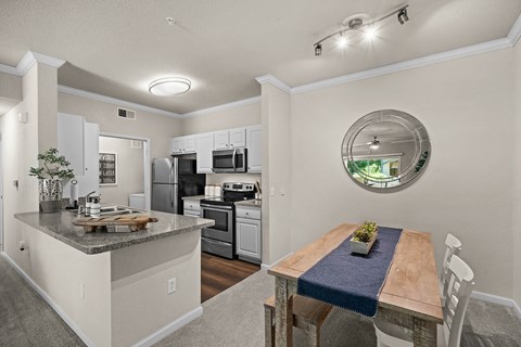 an open kitchen and dining room with stainless steel appliances and a wooden table