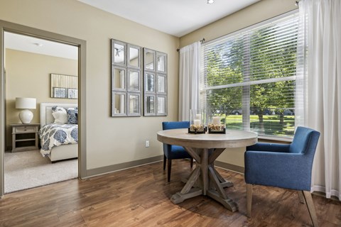 A dining room with a table and chairs.