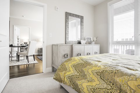 A bedroom with a bed, dresser, and mirror.