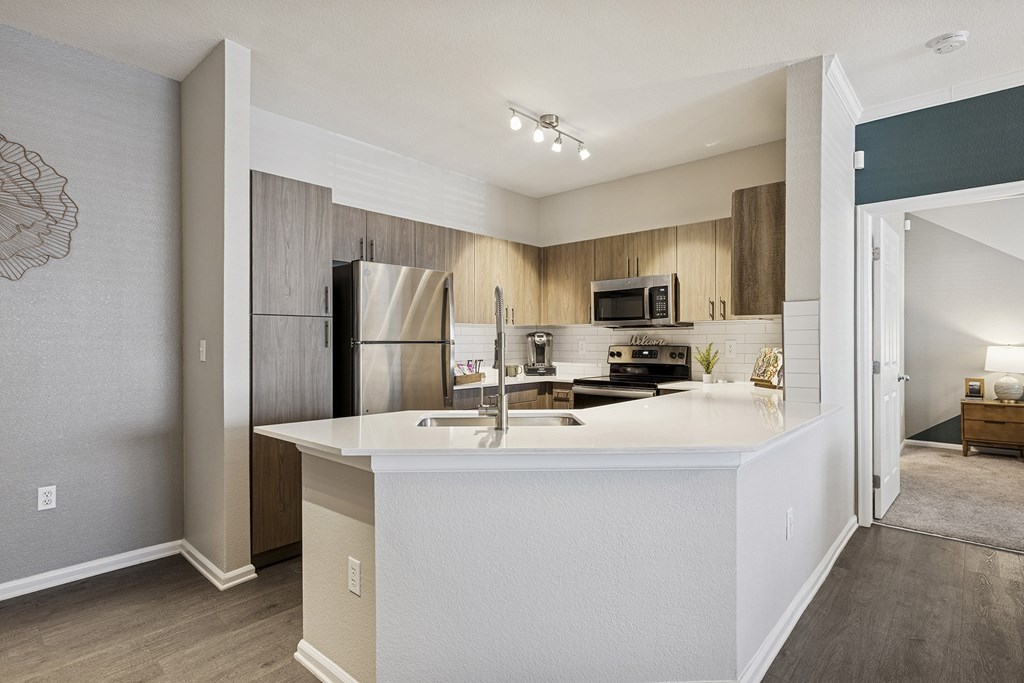 A kitchen with a white countertop and a refrigerator.