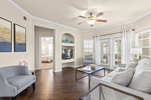 A living room with a grey couch and a glass coffee table.