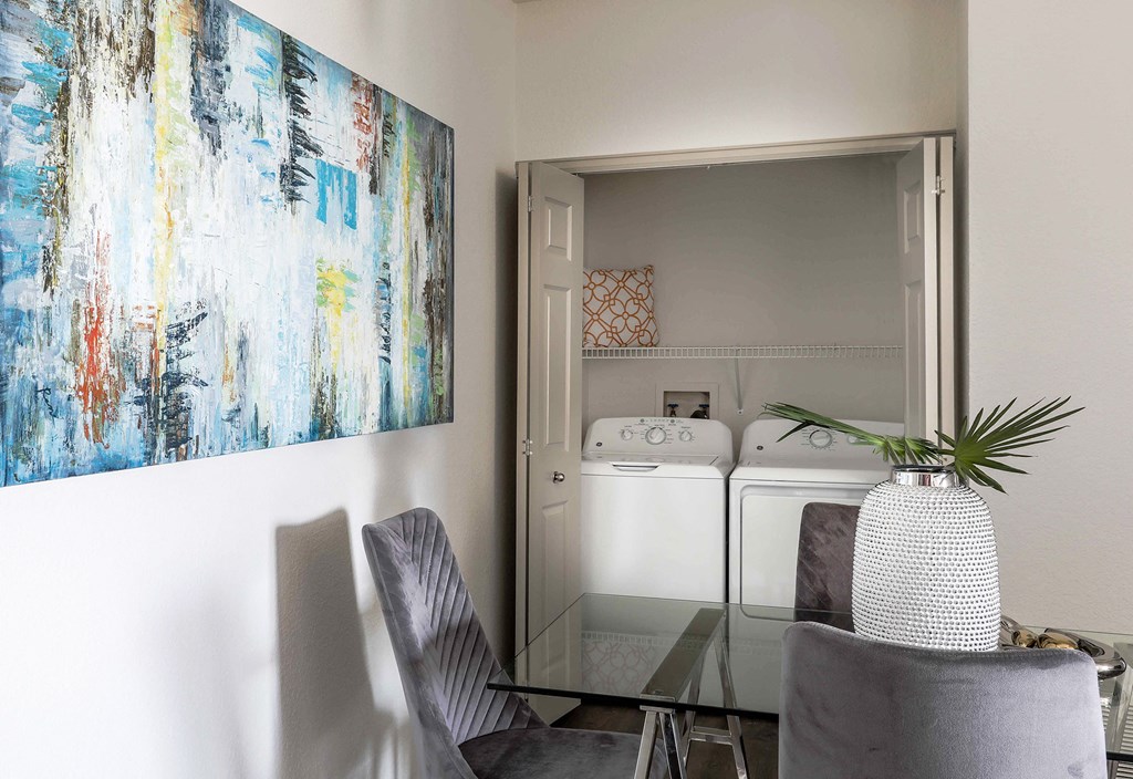a dining room with a table and chairs and a painting on the wall