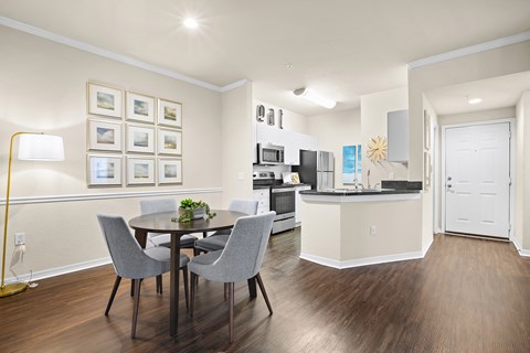 A dining room with a table and chairs.