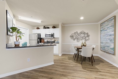 A kitchen with a dining table and chairs.