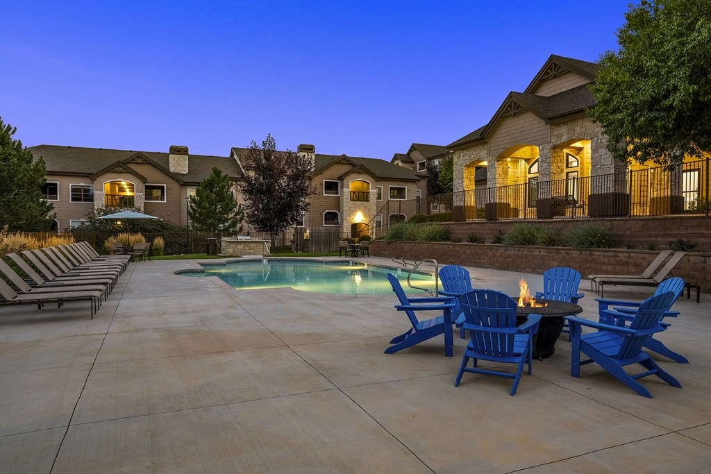 Poolside fire pit lounge at dusk - Grand Centennial Apartments