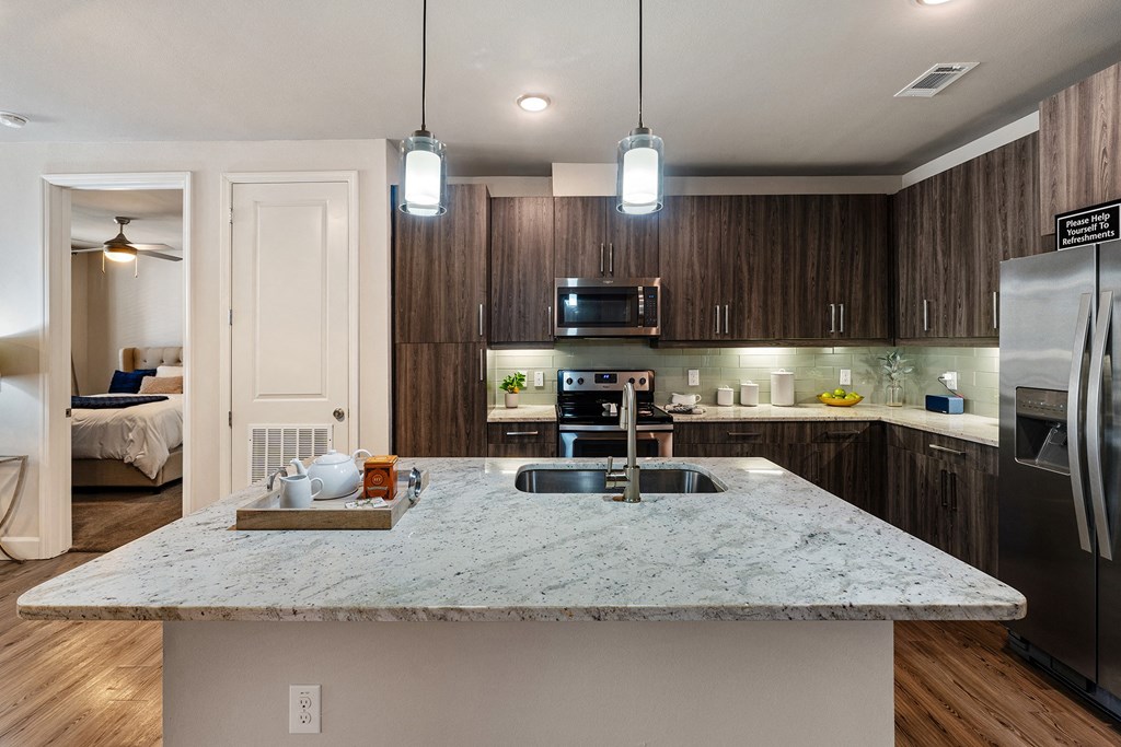 A kitchen with a marble countertop and stainless steel appliances.