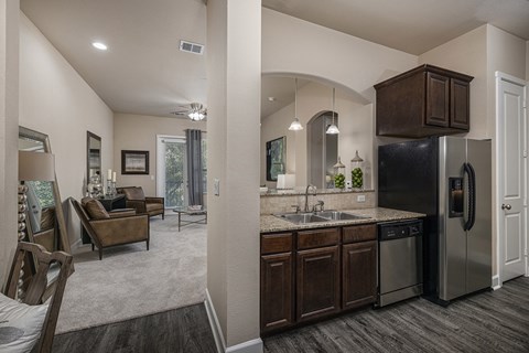 A modern kitchen with dark wood cabinets and stainless steel appliances.