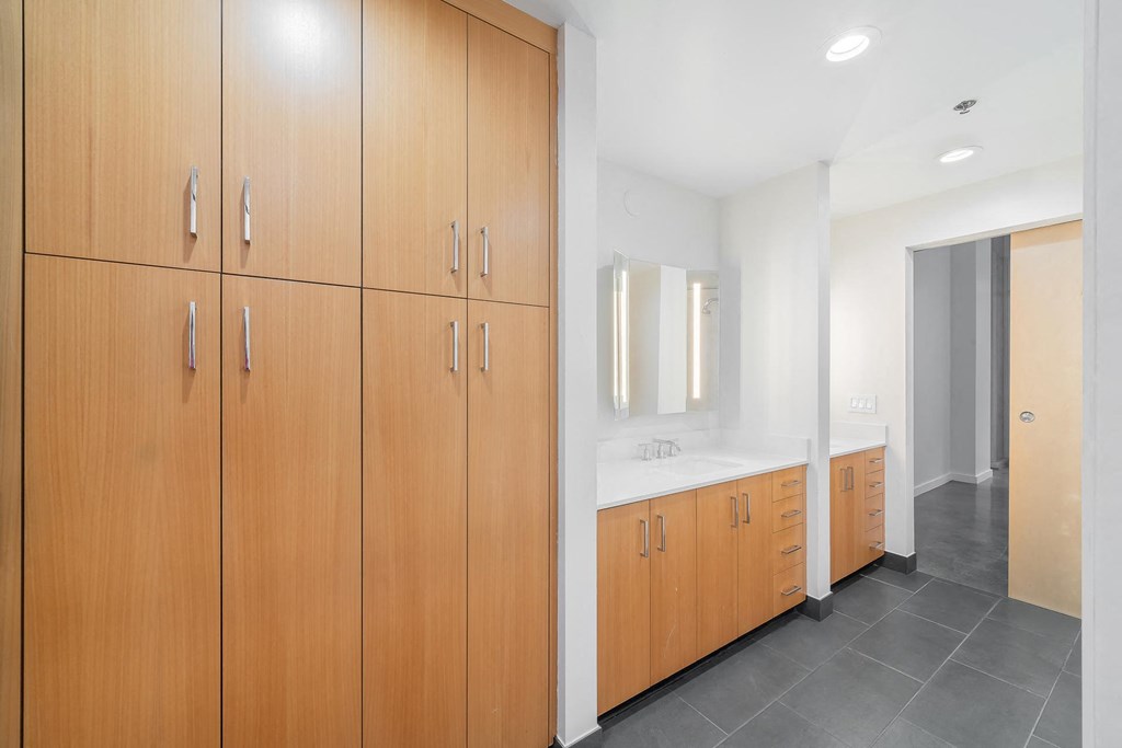 a bathroom with wooden cabinets and a sink and a mirror