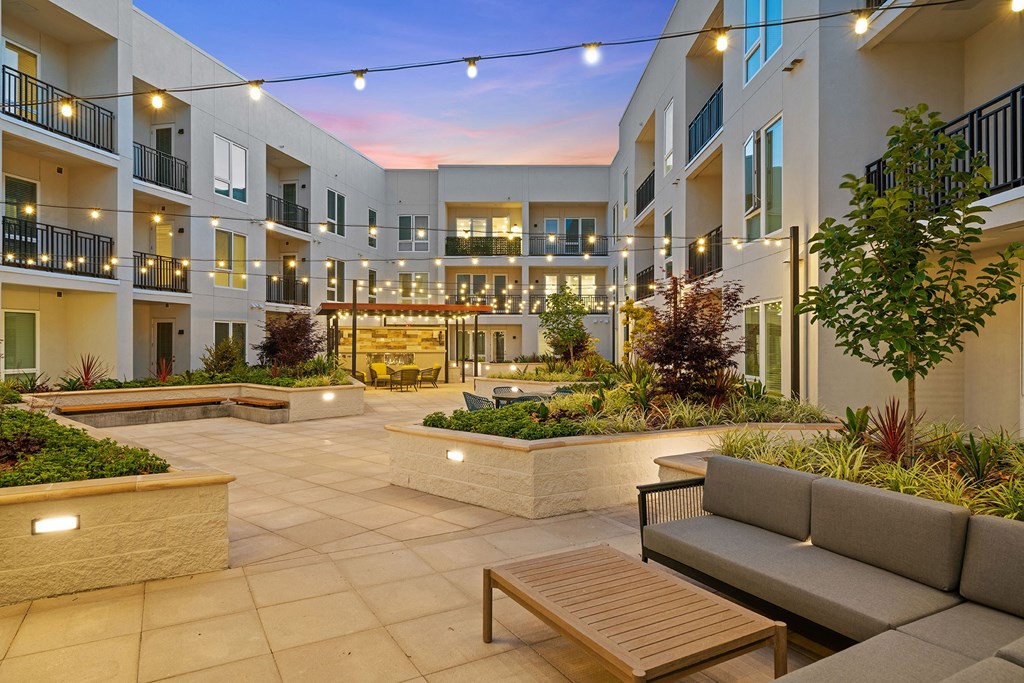 Courtyard with ample seating and romantic lighting - La Via Apartments