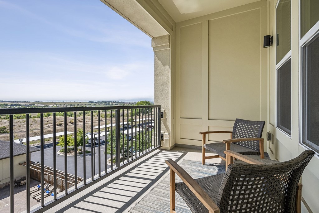 Private patio and balconies available a balcony with two chairs and a table and a view of the ocean