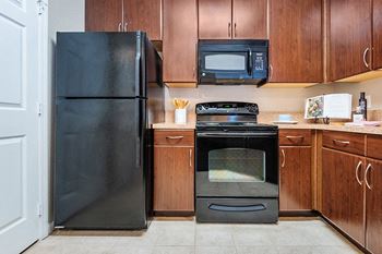 The Crossing at Alexander Place - Contemporary appliances including an under-cabinet mounted microwave in all units