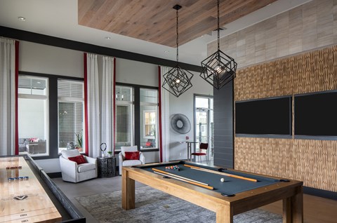 a living room with a pool table and a large window