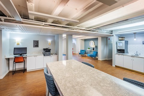 an open office space with a large counter top and a kitchen