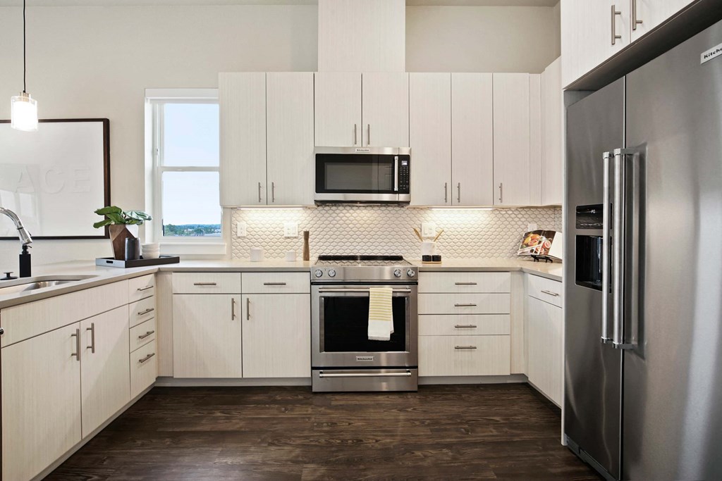 a kitchen with white cabinets and stainless steel appliances