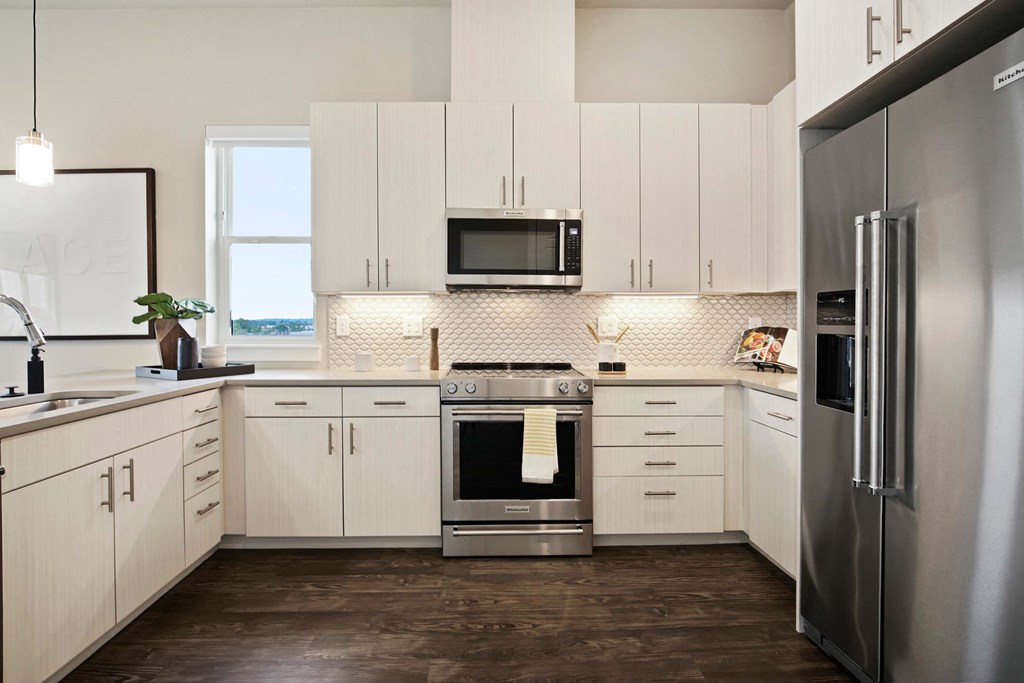 a kitchen with white cabinets and stainless steel appliances
