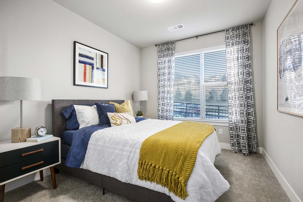 a bedroom with a bed and a large window