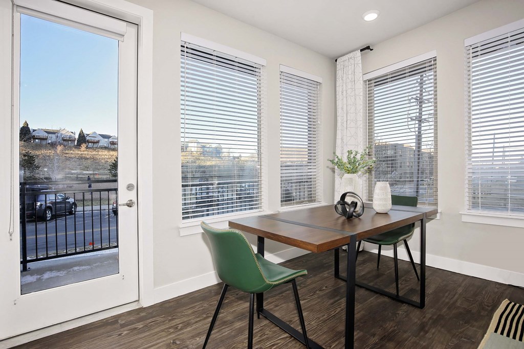 a dining room with a table and chairs and a door to a balcony