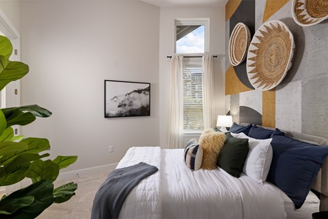 A bedroom with a large bed and a painting on the wall.