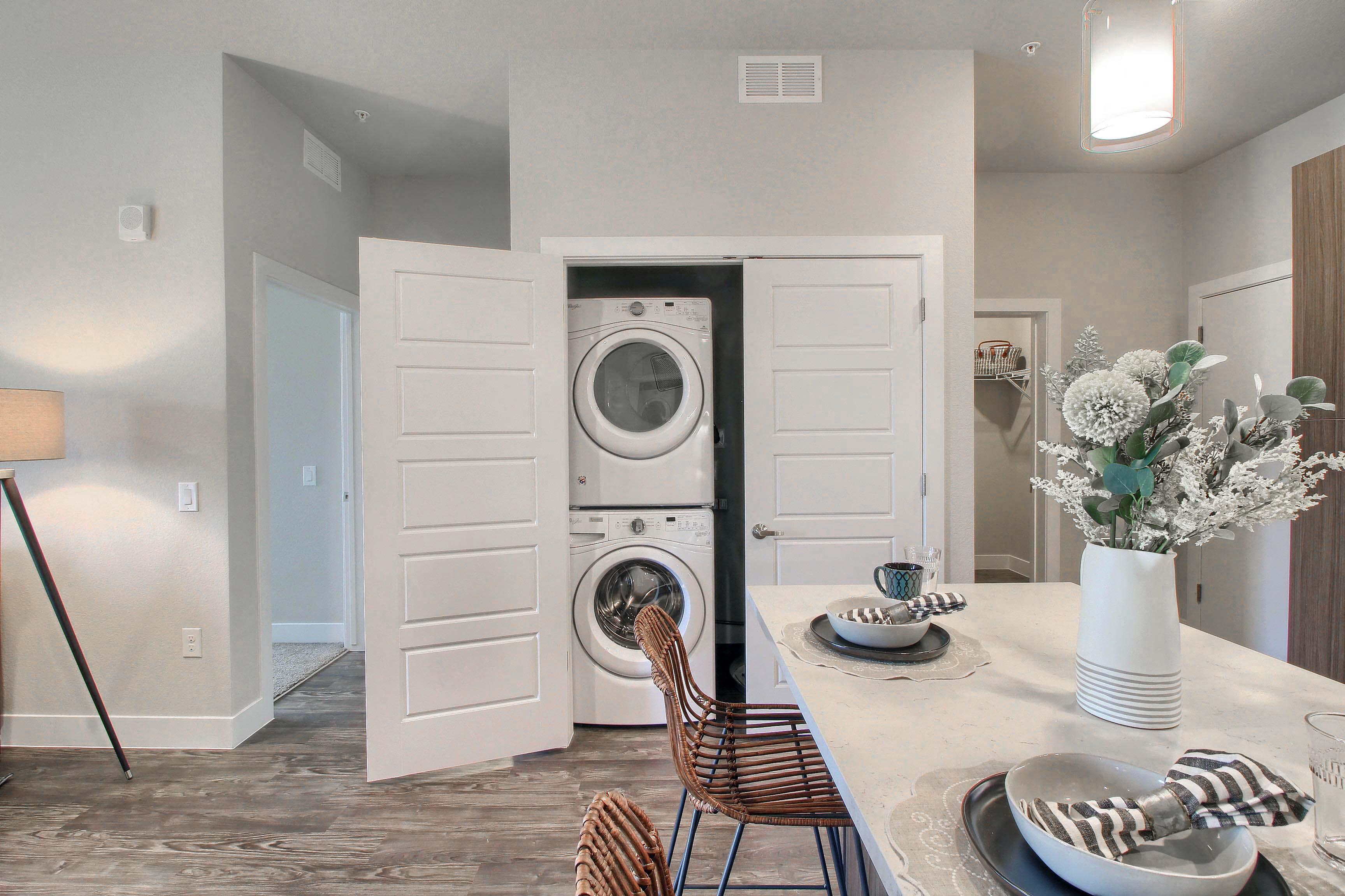 a washer and dryer in a laundry room with a table and chairs