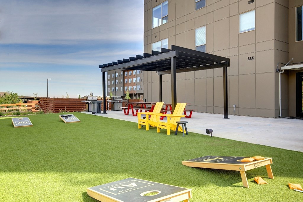 an outdoor area with chairs and tables and a building in the background