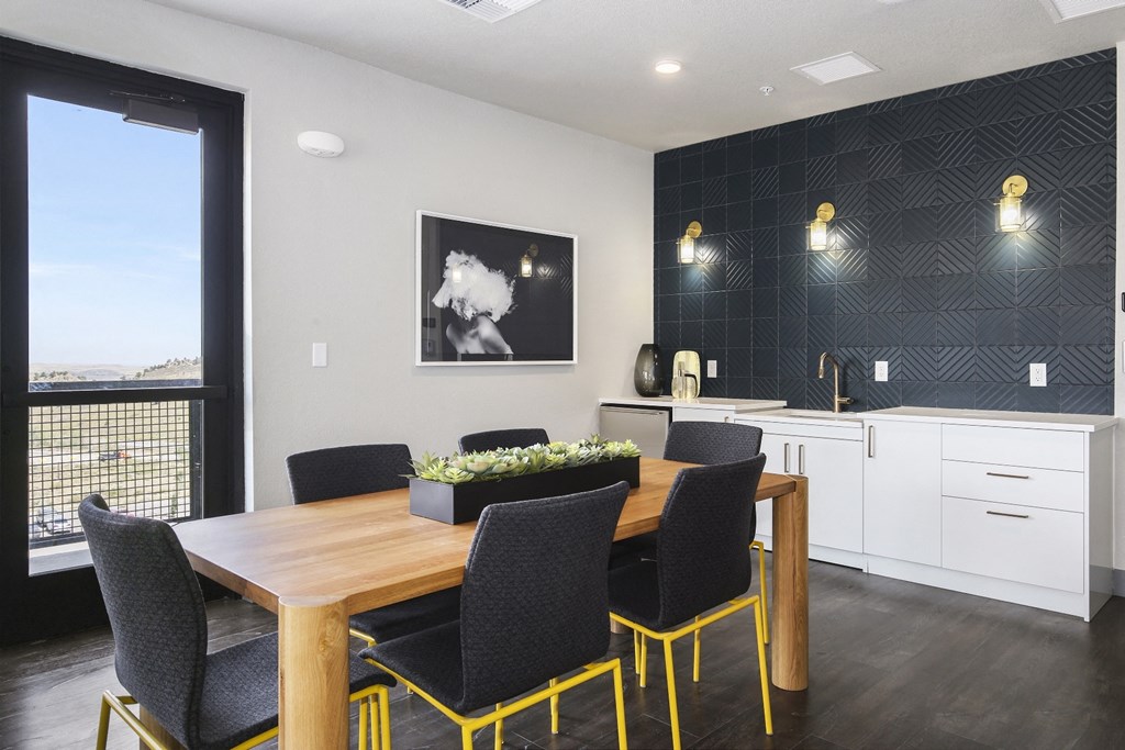 a dining area with a wooden table and chairs and a kitchen with a large window