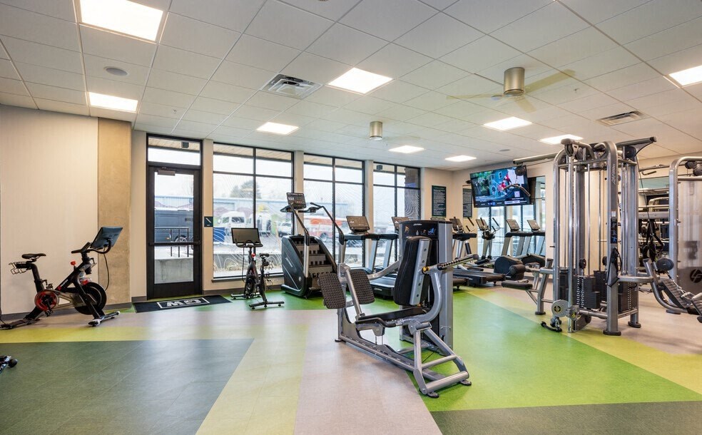 a gym with weights and other exercise equipment and a tv