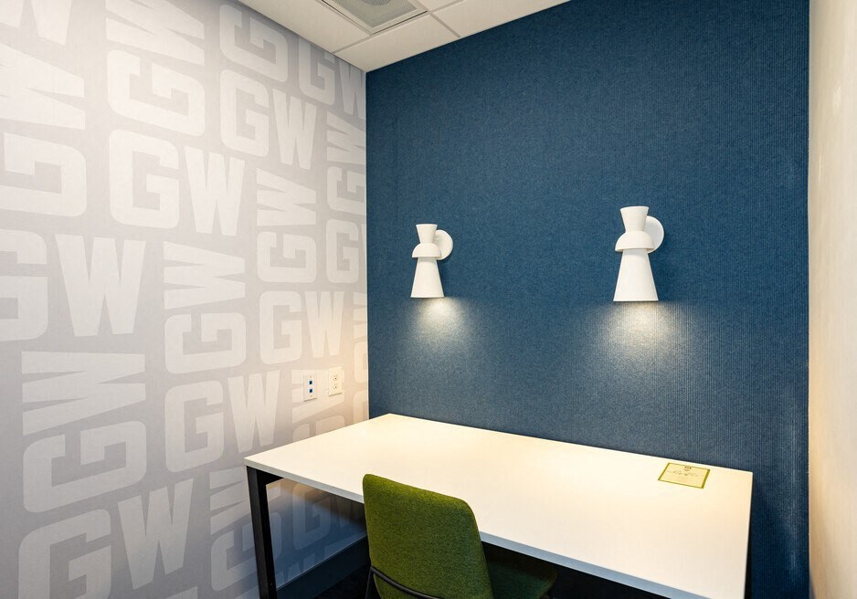 a desk and a chair in a room with a blue wall