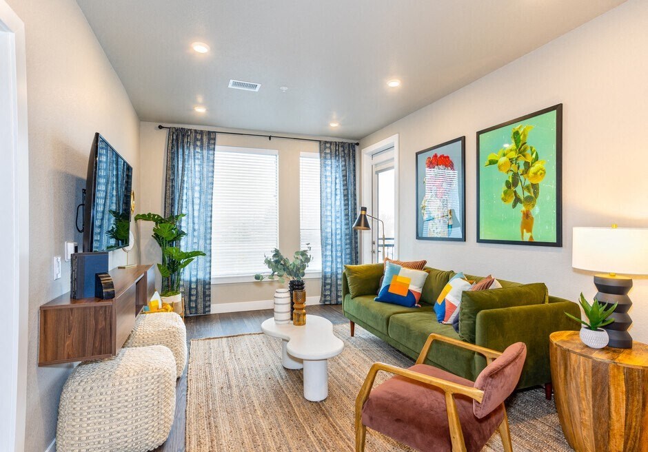 a living room with a green couch and a television
