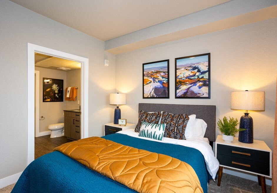 a bedroom with a large bed and a bathroom with a toilet