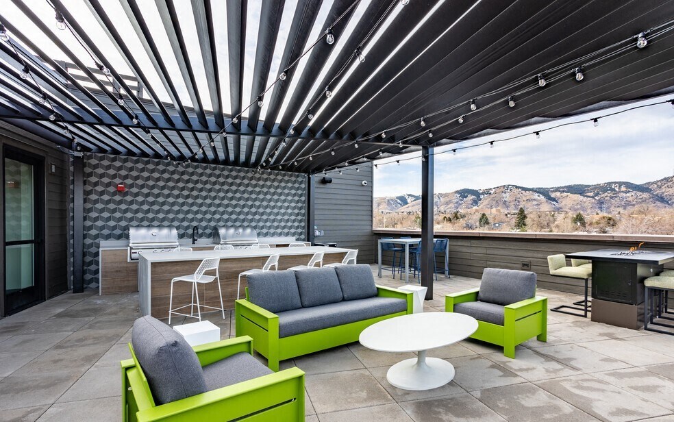a patio with chairs and tables and a view of the mountains