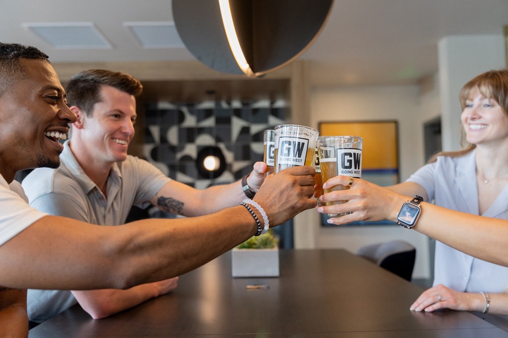 a group of people sitting at a table drinking beer
