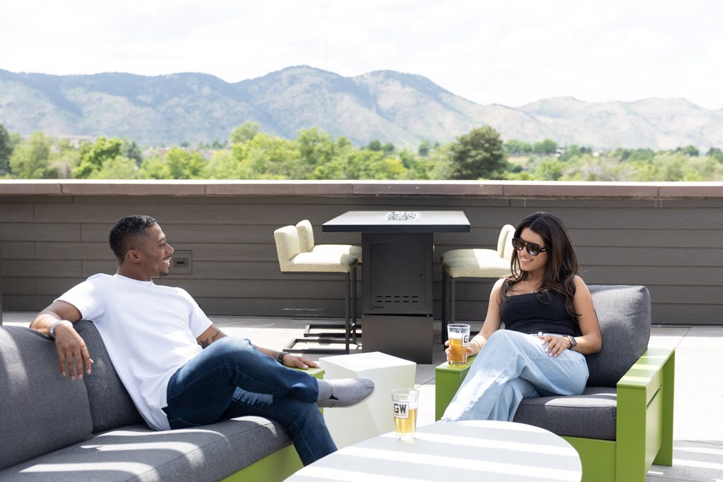 a man and a woman sitting on couches on a patio