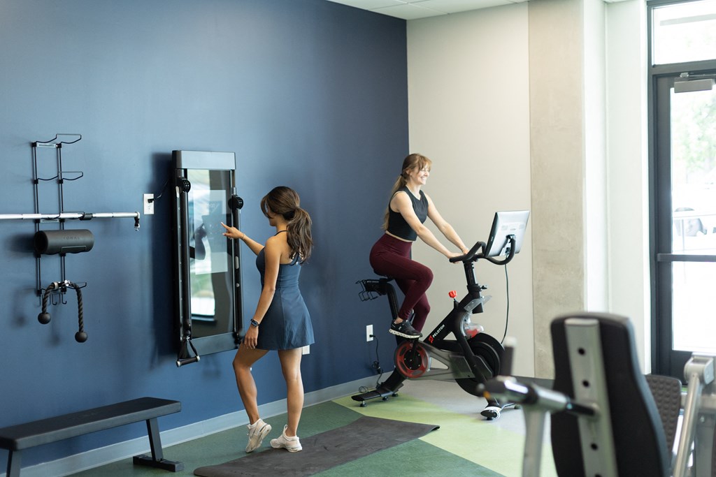 two women working out in a gym on an exercise bike