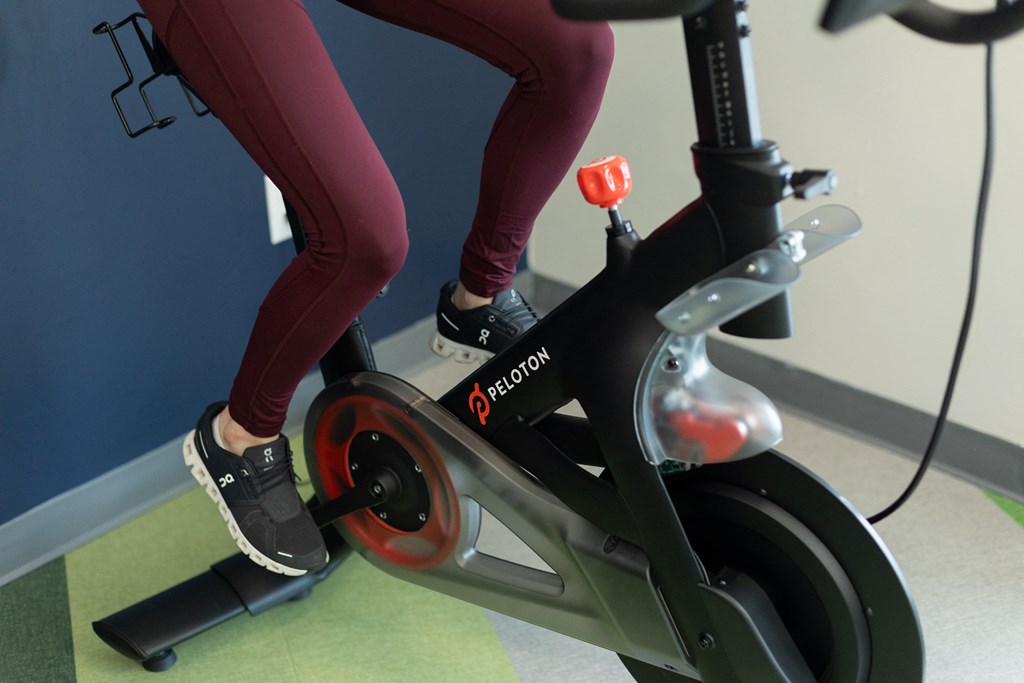 two women riding an exercise bike in a gym