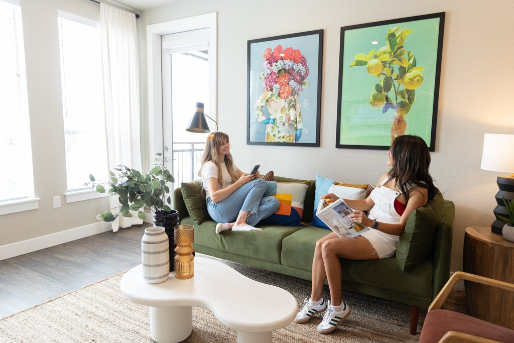 two women sitting on a couch in a living room