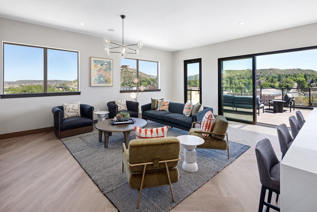 A living room with a large window and a view of the mountains.