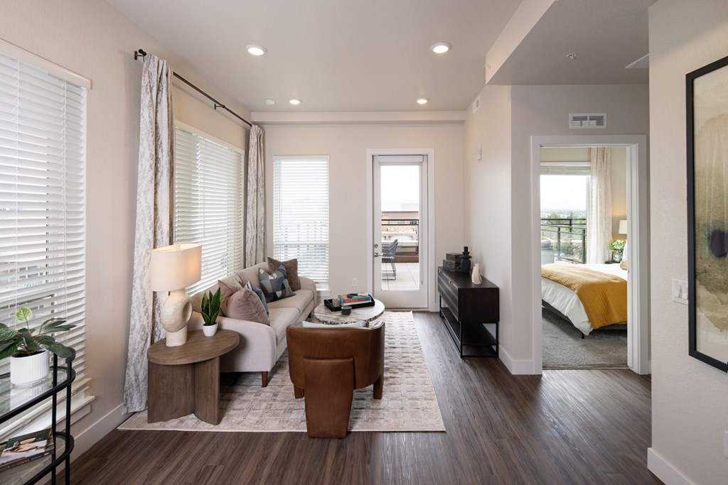 A well-lit, modern living room with a large window and a comfortable seating area.