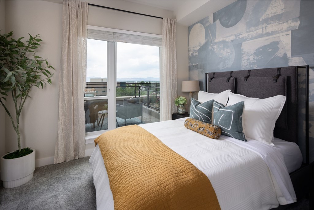 A bedroom with a large bed and a view of the city.