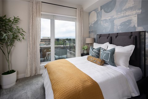 A bedroom with a large bed and a view of the city.