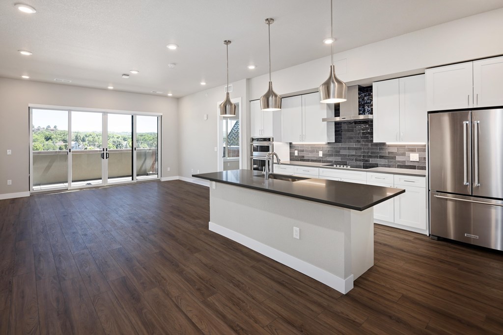 A modern kitchen with a large island and stainless steel appliances.