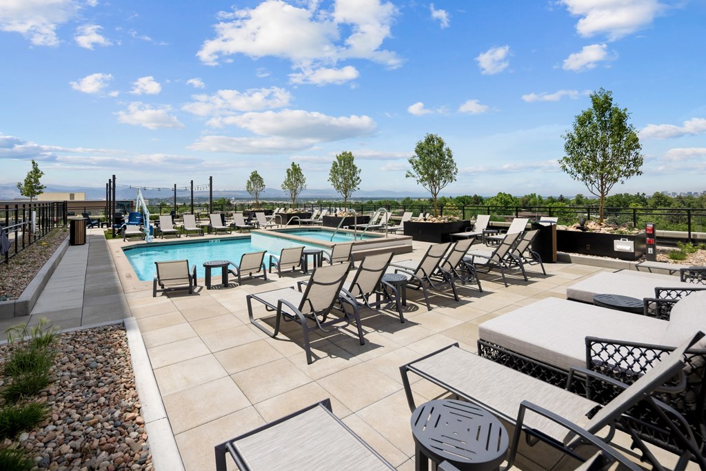 A pool area with chairs and a table.