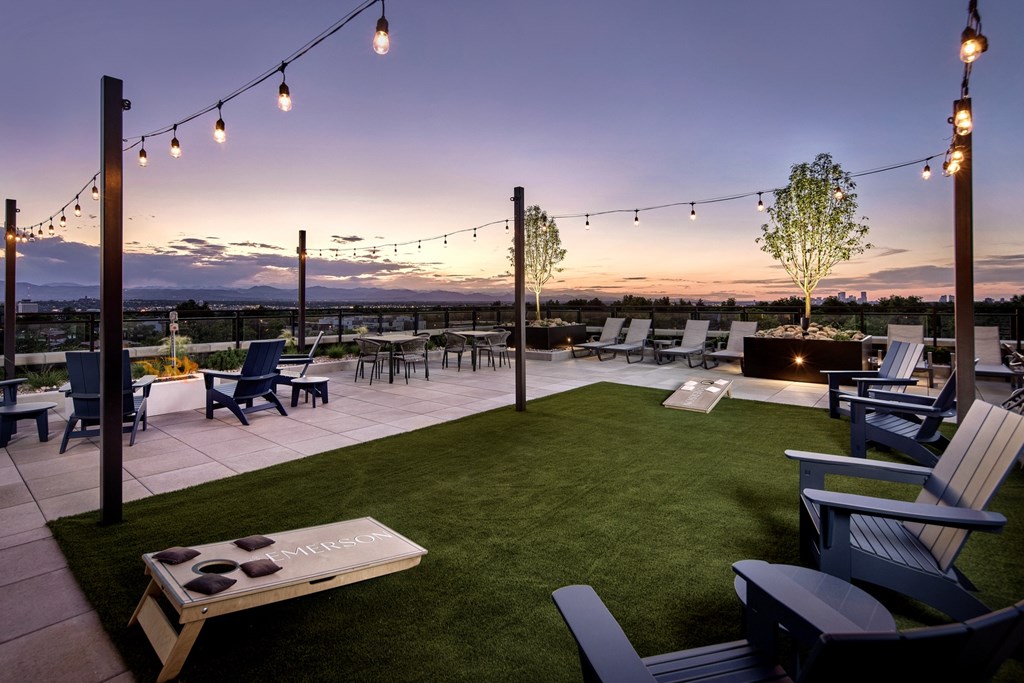 A patio with lawn chairs and a picnic table is set up for an evening of relaxation.
