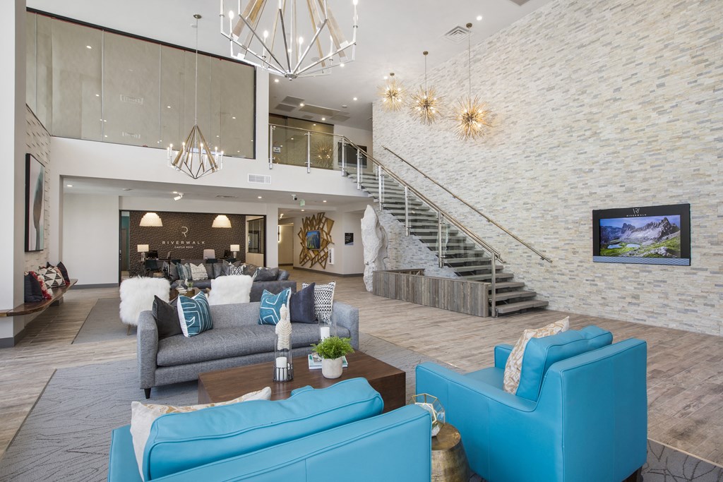 a living room with blue furniture and a staircase