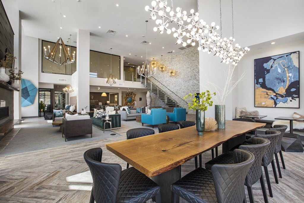 the living room and dining area of a house with a long wooden table and chairs