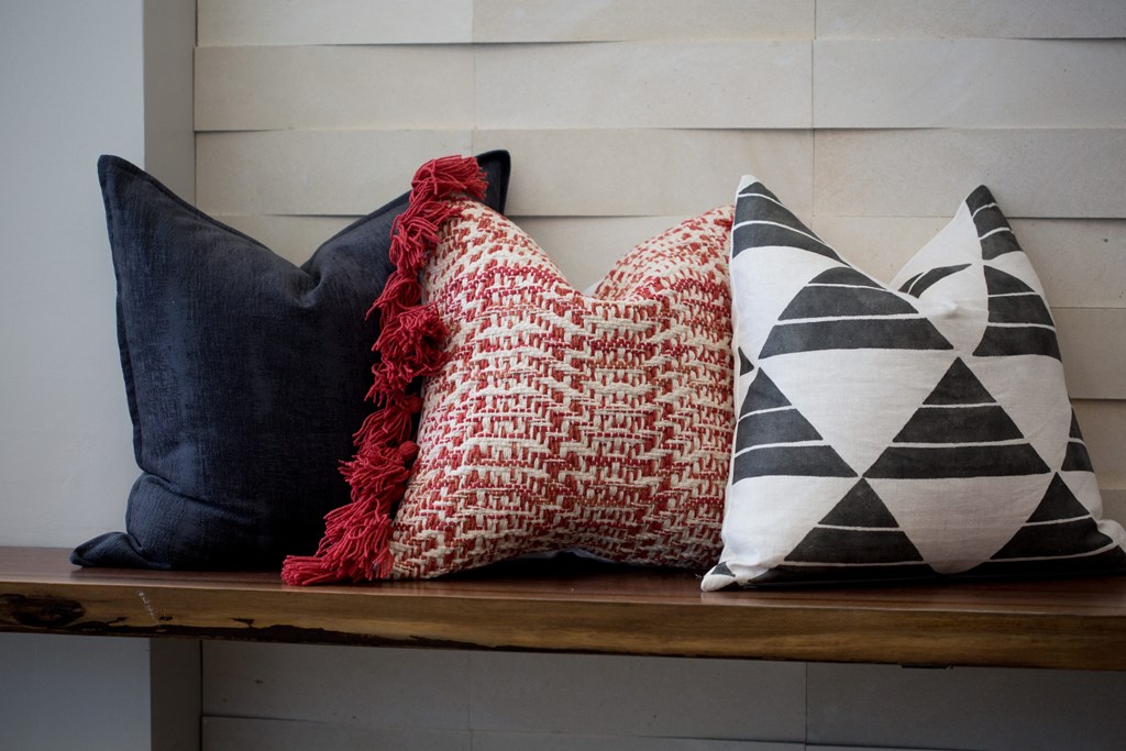 two pillows sitting on a bench with a red blanket