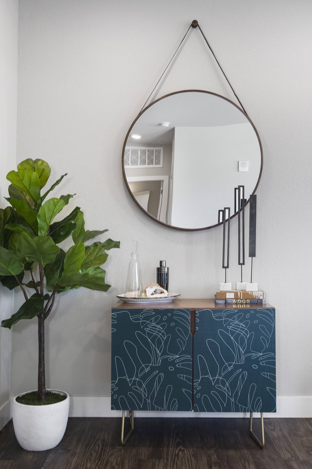a blue cabinet with a mirror and a plant in a room