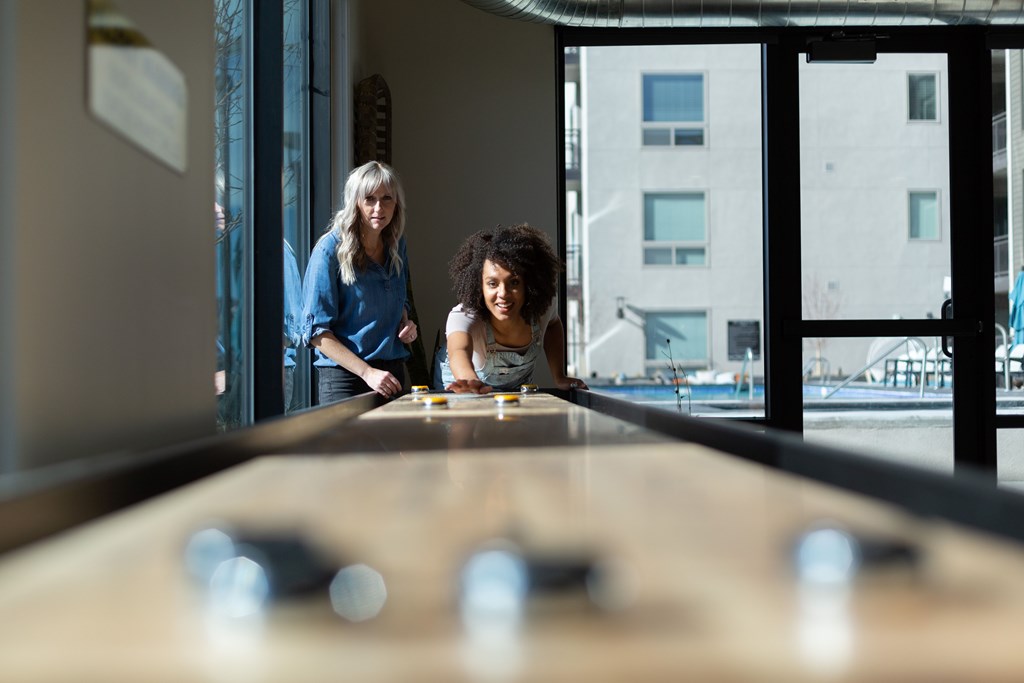 Two people playing a game of shuffleboard.
